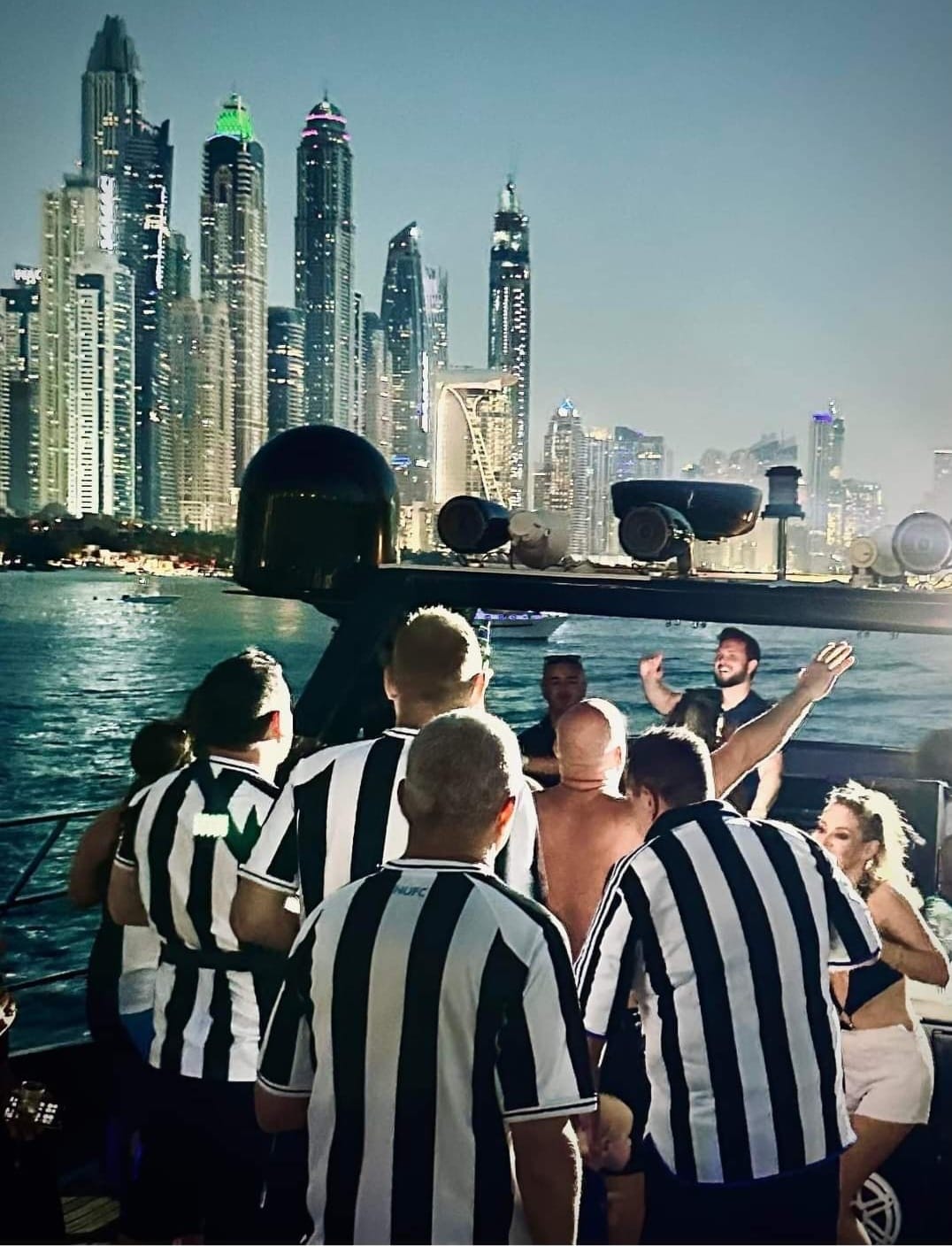 Dubai Mags fans on boat with Dubai Marina skyline at night